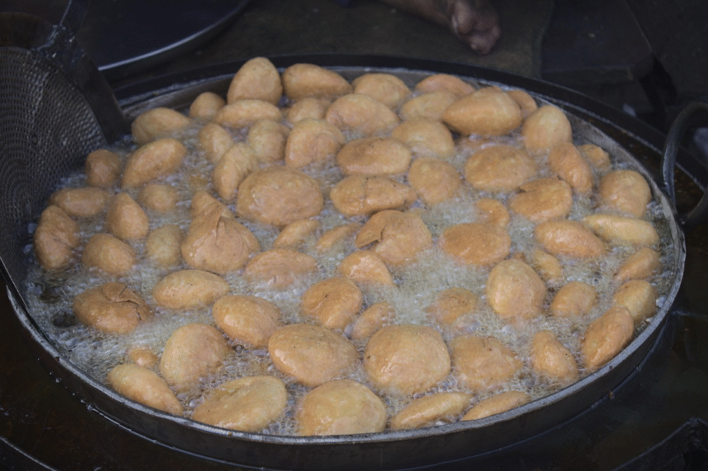 Pyaaz kachori frying to golden perfection in oil, a delicious street food