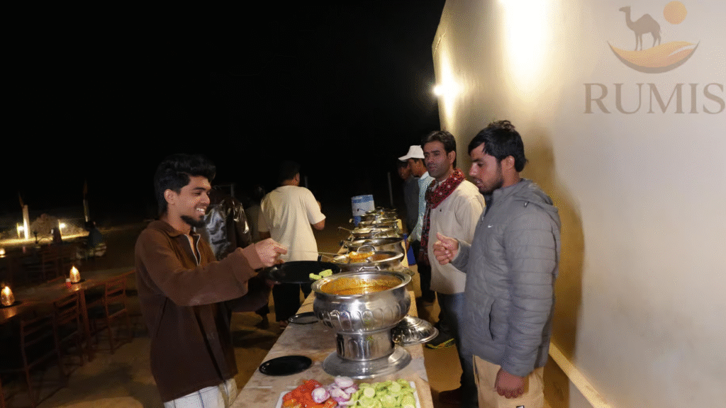 Guests line up as staff serve a colorful buffet of traditional dishes during an immersive Rajasthan culinary journey at a desert camp.